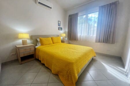 The primary bedroom has queen bed with bright bedding and a Smart TV